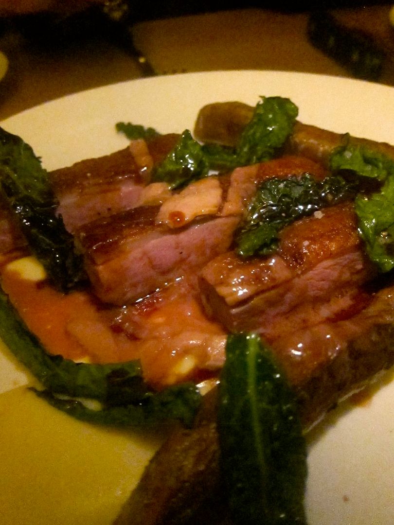 Shaved foie gras tops roasted duck breast with white sweet potato log and roasted kale.