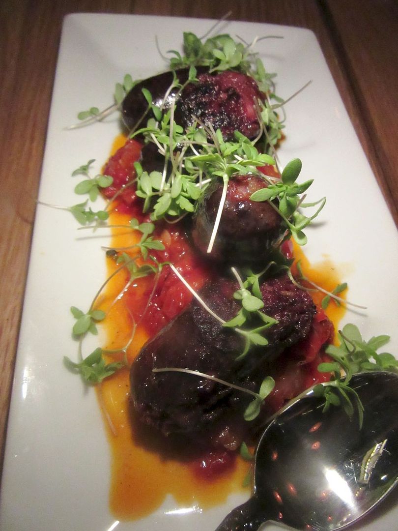 Feisty blood sausage is cut into pieces and served atop peppery peppers.